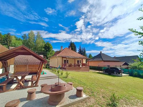a backyard with a picnic table and a house at Relax Wellness Apartman in Parádsasvár