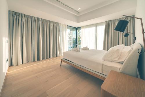 - une chambre avec un grand lit et des oreillers blancs dans l'établissement Villa Pausilypon, à Prévéza