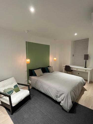 sypialnia z łóżkiem, krzesłem i biurkiem w obiekcie Nouveau Superbe grand T2 centre ville w mieście Pertuis