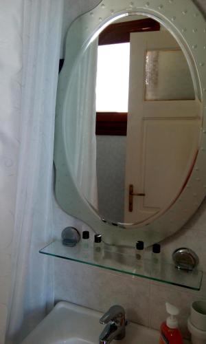a bathroom sink with a mirror and a window at Ενάλιον in Astypalaia