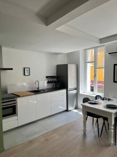 a white kitchen with a refrigerator and a table at Nouveau Superbe grand T2 centre ville in Pertuis