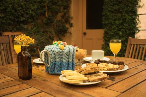 a wooden table with a plate of food and a glass of wine at Posada Los Mimbres in Gaiman