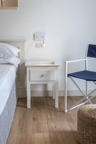a white desk with a chair next to a bed at Murè Hotel Numana in Numana