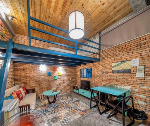 a room with a brick wall and two tables at Stay&Chill - S.1: Ancient studio nearby Bui Vien in Ho Chi Minh City