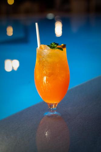 a glass of orange juice sitting on a table at Riviera Perdika Hotel in Perdika