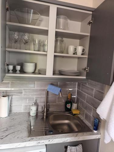 um lavatório de cozinha com pratos e pratos nas prateleiras em Parkhill House Self Catering em Ballyshannon