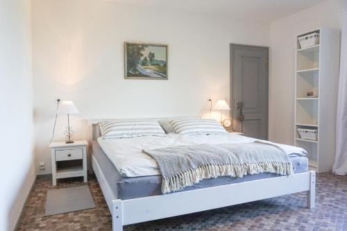 a white bed in a bedroom with a white wall at Ferienwohnung Nina in Egestorf