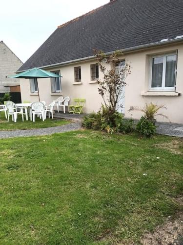 une maison avec une table et des chaises dans la cour dans l'établissement Maison pavillonnaire, à Lanvollon
