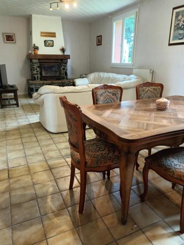 un salon avec une table, des chaises et un canapé dans l'établissement Maison pavillonnaire, à Lanvollon