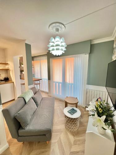 - un salon avec un canapé et un lustre dans l'établissement «La Petite Escapade à Deauville» PLACE MORNY, à Deauville