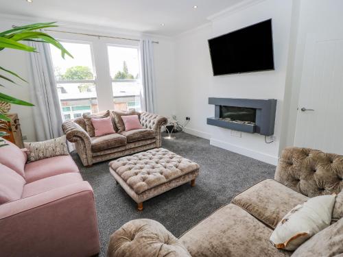 a living room with couches and a fire place at 23a High Street in Edwinstowe