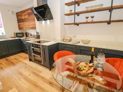 a kitchen with a glass table with a plate of food at 23a High Street in Edwinstowe