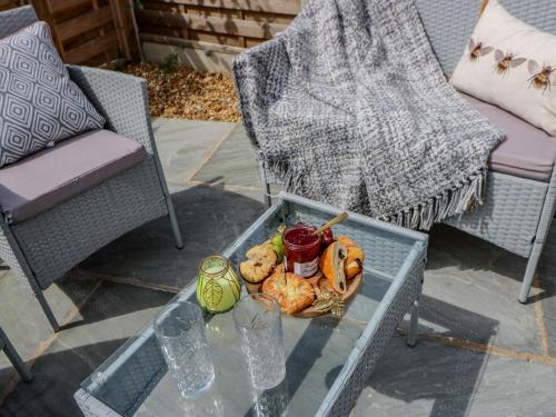 a tray of food on a glass table with chairs at 23a High Street in Edwinstowe