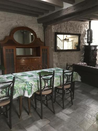 a dining room with a table and chairs and a mirror at La Casona del Tío Pedro in Cadalso de los Vidrios