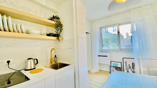 a kitchen with white cabinets and a sink and a window at New Designer Studio next to Casino Square with AC & Internet in Monte Carlo