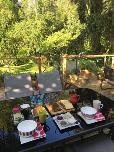 a table with plates of food on it at Un coin de forêt in Courmas