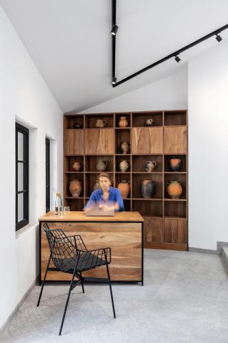 a woman sitting at a counter in a room with a chair at Bridges Residence in Veliko Tŭrnovo