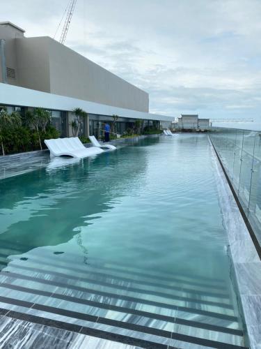 a swimming pool in front of a building at Luxury The Song Vung Tau Apartment Homestay in Vung Tau