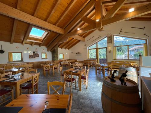 ヴァルディデントロにあるHotel San Carlo, tra Bormio e Livignoの木製のテーブルと椅子が備わる空きレストランです。