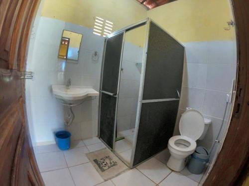 a bathroom with a shower and a toilet and a sink at Pires House Beach Maramar in Luis Correia