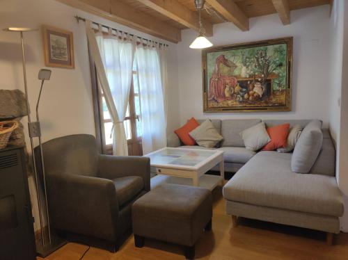 uma sala de estar com um sofá, cadeiras e uma mesa em Antigua Casa Chato - tucasaenlospirineos em El Pueyo de Jaca