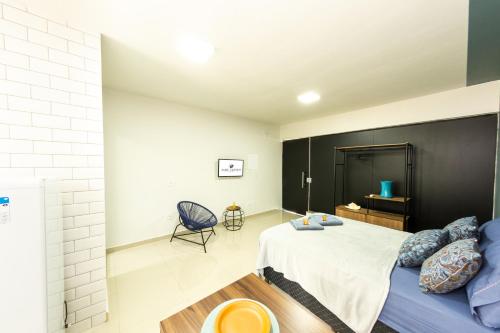 a bedroom with a large bed and a chair at Jahu Center Plaza Flats in Jaú