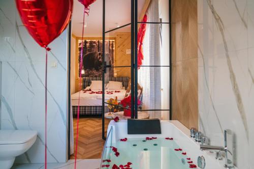 a bathroom with a tub and a room with a bed at GORSKI RESORT Lux Apartments Jacuzzi & Sauna in Poronin