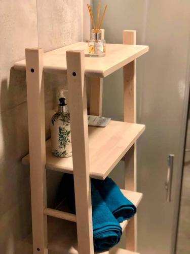 a wooden shelf in a bathroom with blue towels at Studija JV36 in Juodkrantė