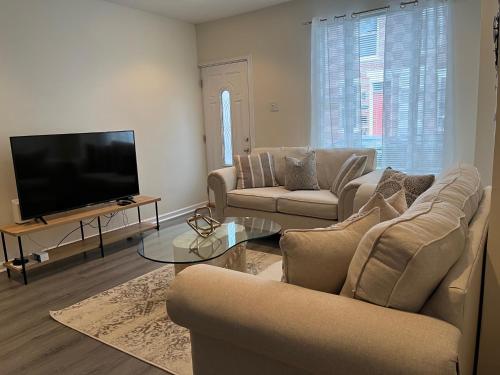 a living room with two couches and a flat screen tv at Cozy Home located in a prime area. in Philadelphia