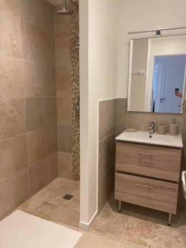 une salle de bain avec un lavabo et un miroir dans l'établissement Gîte Les Muguets - 4 personnes - confort et vue imprenable, à Largentière