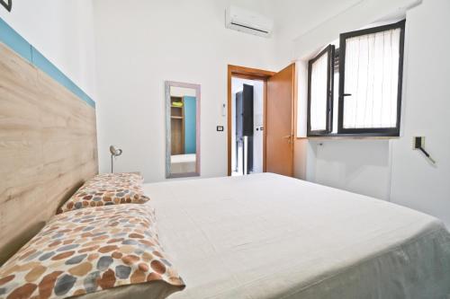 Cama grande en habitación con ventanas en Appartamento Porta Napoli, en Brindisi