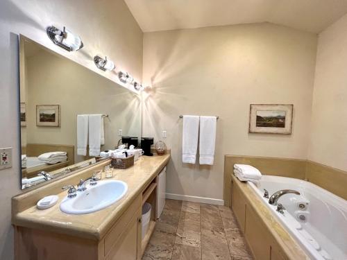 a bathroom with a sink and a tub and a mirror at Petit Logis Inn in Yountville