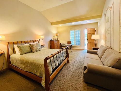 a large bedroom with a bed and a couch at Petit Logis Inn in Yountville