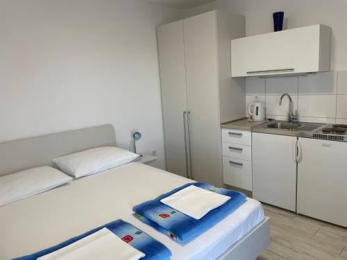 a small room with a bed and a kitchen at Apartment Maxim in Primošten