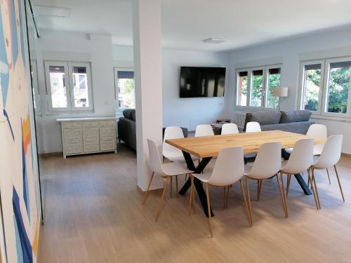 a dining room and living room with a table and chairs at Villa El Encinar de Noja in Noja