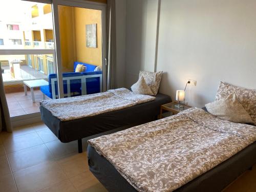 a hotel room with two beds and a balcony at Family Heaven - No Stress Holidays in El Cotillo