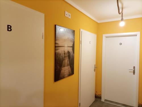 a hallway with yellow walls and a picture on the wall at Hotel An der Karlstadt in Bremerhaven
