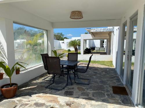 un patio con mesa y sillas en un porche en Moderna casa con piscina a 10 min de la playa, en Coclé