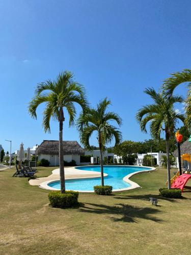 una piscina con palmeras en un parque en Moderna casa con piscina a 10 min de la playa en Coclé