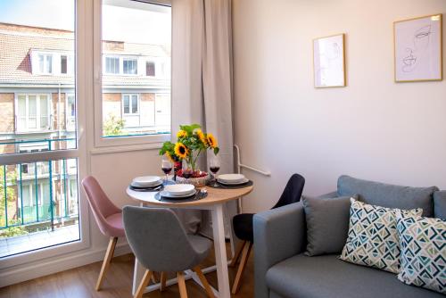 - un salon avec une table, un canapé et une fenêtre dans l'établissement Maya's Flats & Resorts 61 - Most Miłości, à Gdańsk