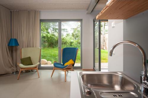 uma cozinha com 2 cadeiras e um lavatório em FELDGANG ein Gästehaus! em Upahl