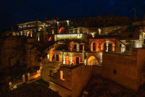 a building on the side of a mountain at night at Fairyland Cave Hotel in Goreme