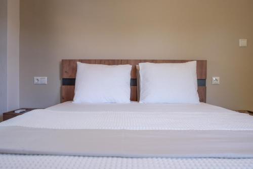 łóżko z białą pościelą i 2 poduszkami w obiekcie Μελίτη Pelion Luxury Living w mieście Zagora