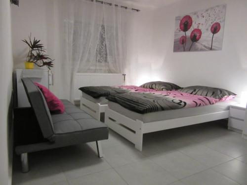 1 dormitorio con 2 camas y 1 silla en Vila Rybníček, en Brada