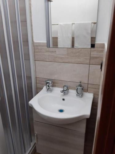 a bathroom with a white sink and a mirror at Guesthouse da Caterina in San Giovanni