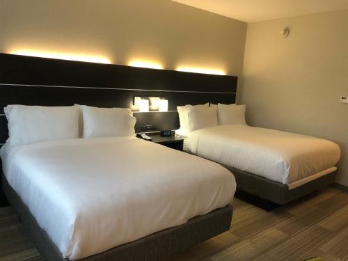 two beds in a hotel room with white sheets at Holiday Inn Express & Suites Warrensburg North by IHG in Warrensburg