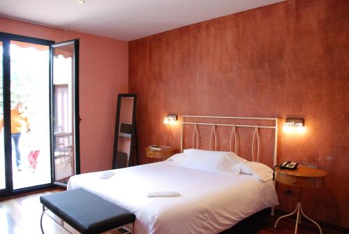 a hotel room with a bed and a person walking out the window at Hotel Dom in Organyà