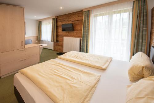 a hotel room with two beds and a television at Embacherhof in Embach