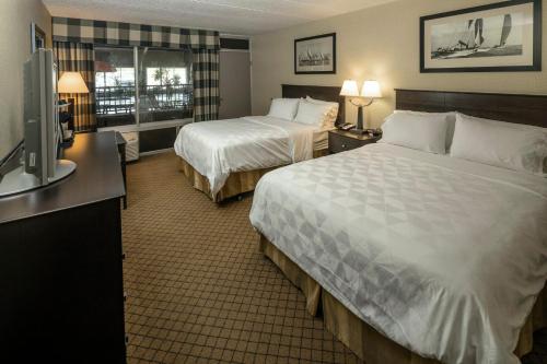 a hotel room with two beds and a television at Holiday Inn Detroit Lakes by IHG in Detroit Lakes