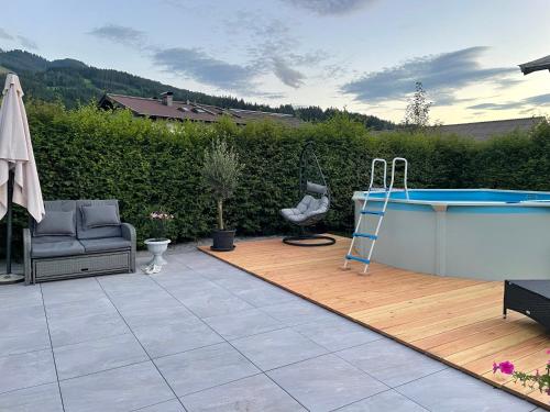 eine Terrasse mit einem Pool, einem Stuhl und einem Tisch in der Unterkunft Appartementhaus FICHTERN in Sankt Johann in Tirol